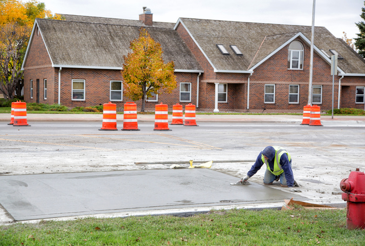 A worker works on a street surface.