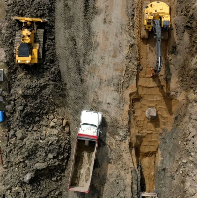 Overhead photo of machines and dirt at a construction site.