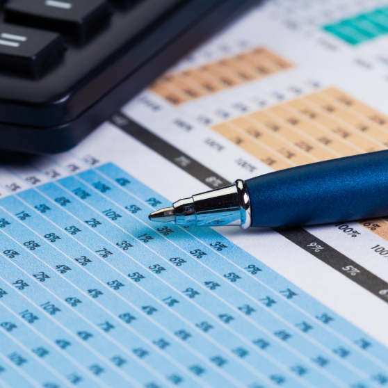 A pen and calculator on paper with numbers.