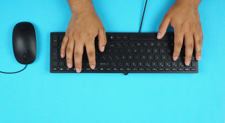 Hands on computer keyboard with mouse